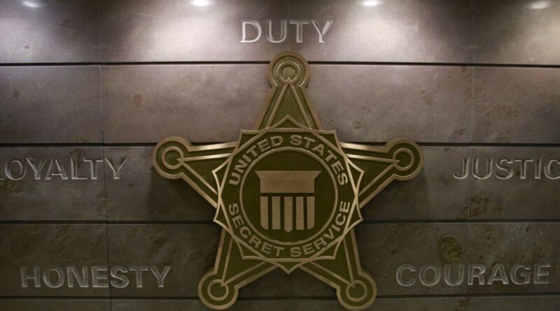Selo do Secret Service dos EUA exibido em parede com valores da agência