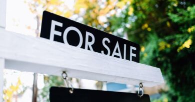 Placa de For Sale (vende-se) em frente a uma casa