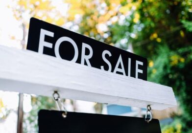 Placa de For Sale (vende-se) em frente a uma casa